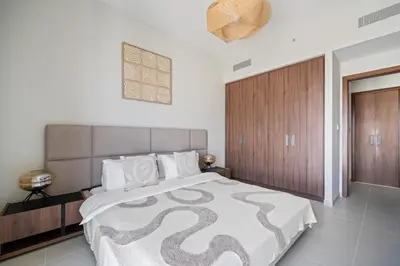a bedroom with a large bed and a wooden door at Harbour Oasis - Vida Residences - Creek Harbour in Dubai