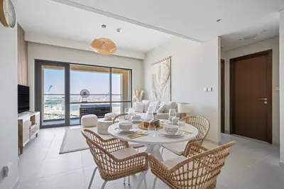 a dining room with a white table and chairs at Harbour Oasis - Vida Residences - Creek Harbour in Dubai