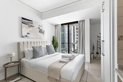 a white bedroom with a large bed and a window at Stonetree - Goldcrest Views 2 - Prime Location in Dubai