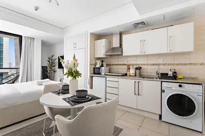a kitchen and living room with a bed and a table at Stonetree - Goldcrest Views 2 - Prime Location in Dubai