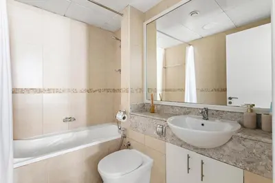 a bathroom with a sink and a toilet and a mirror at Stonetree - Goldcrest Views 2 - Prime Location in Dubai