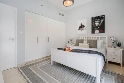 a bedroom with white walls and a white bed at Trophy - Discover Tranquility Living in this Sleek Sanctuary in Dubai
