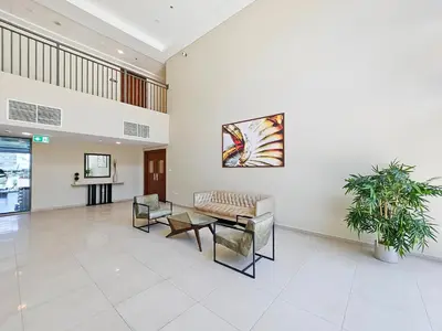 a lobby with a couch and chairs and a table at Trophy - Discover Tranquility Living in this Sleek Sanctuary in Dubai