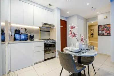 a kitchen and dining room with a table and chairs at Trophy - Discover Tranquility Living in this Sleek Sanctuary in Dubai