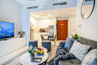 a living room with a couch and a table at Trophy - Discover Tranquility Living in this Sleek Sanctuary in Dubai