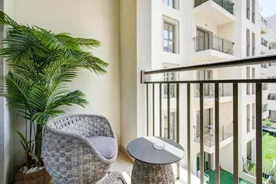 a balcony with a table and chairs and a plant at Trophy - Discover Tranquility Living in this Sleek Sanctuary in Dubai