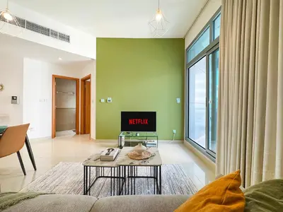 a living room with a couch and a tv at Trophy - Magical Marina 1BDR connected to Metro Station in Dubai