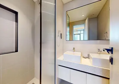 a bathroom with two sinks and a mirror at Waterfront ,High Floor 2BED with Private Beach Access in Dubai