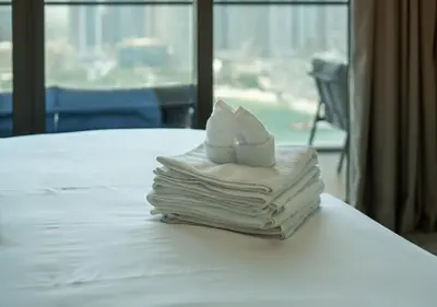 a stack of folded towels sitting on a bed at Waterfront ,High Floor 2BED with Private Beach Access in Dubai