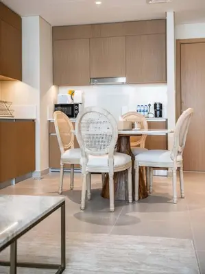 a kitchen with a table and chairs in a room at Serenity Cove: 1BR Luxury Beach Retreat in Dubai