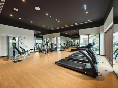a gym with several treadmills and elliptical machines at Serenity Cove: 1BR Luxury Beach Retreat in Dubai