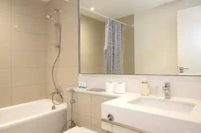 a bathroom with a sink and a tub and a mirror at Park Point C-1 bedroom for monthly stay-1003 in Dubai