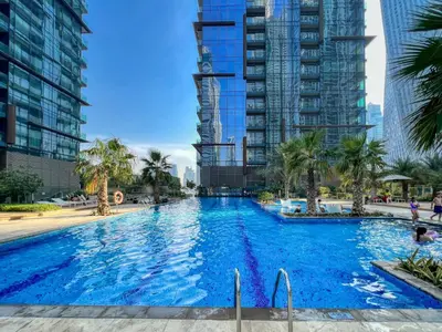 a large swimming pool in a city with tall buildings at Luxury 1BR Apartment in Dubai Marina Gate in Dubai