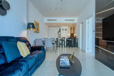a living room with a blue couch and a table at Luxury 1BR Apartment in Dubai Marina Gate in Dubai