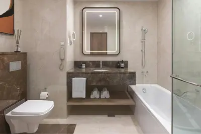 a bathroom with a sink and a tub and a toilet at Marriott Hotel Production City, Dubai in Dubai
