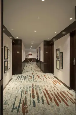 a hallway with a large rug on the floor at Marriott Hotel Production City, Dubai in Dubai