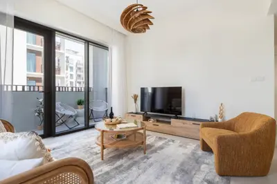 a living room with a tv and a couch and a table at Frank Porter - Bayshore at Creek Beach in Dubai
