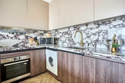 a kitchen with a sink and a washing machine at Frank Porter - Emaar Residences Dubai Marina in Dubai