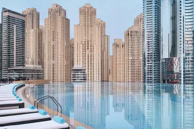a view of a city from a swimming pool with buildings at Frank Porter - Emaar Residences Dubai Marina in Dubai