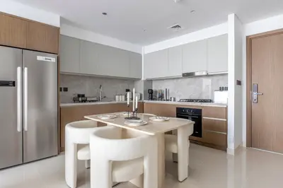 a kitchen with a table and some white appliances at 2BR Beachfront Gem with Dazzling Views of the Palm in Dubai