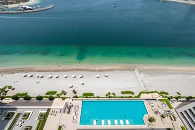 an aerial view of a beach and a swimming pool at 2BR Beachfront Gem with Dazzling Views of the Palm in Dubai