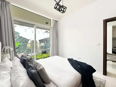 a bedroom with a bed and a large window at Trophy - Springs Suite with Cozy Balcony Garden in Dubai