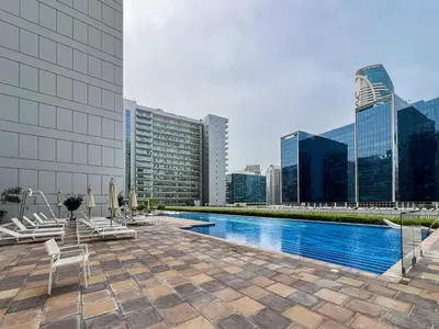 a pool on the roof of a building with buildings at Trophy - Springs Suite with Cozy Balcony Garden in Dubai