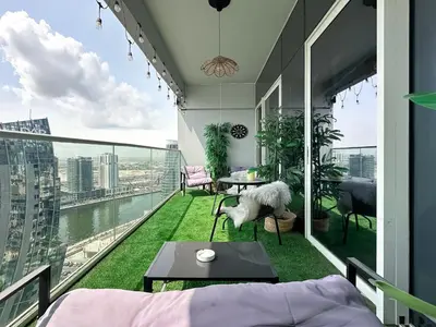 a room with a balcony with a view of the city at Trophy - Springs Suite with Cozy Balcony Garden in Dubai