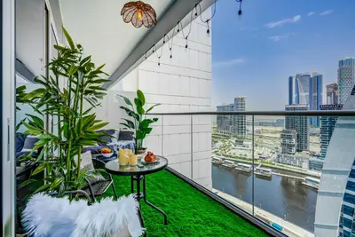 a balcony with a table and a view of the city at Trophy - Springs Suite with Cozy Balcony Garden in Dubai