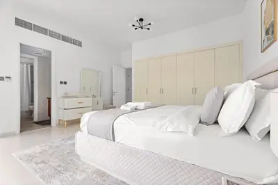 a white bedroom with a large white bed with white pillows at Whole 3 BR with Maids Room House - The Springs - Privat Garden in Dubai