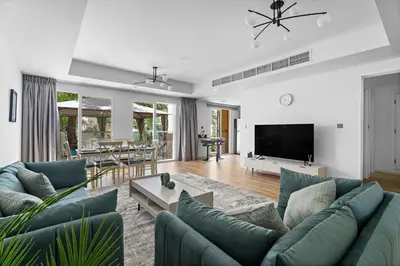 a living room with blue couches and a tv at Whole 3 BR with Maids Room House - The Springs - Privat Garden in Dubai