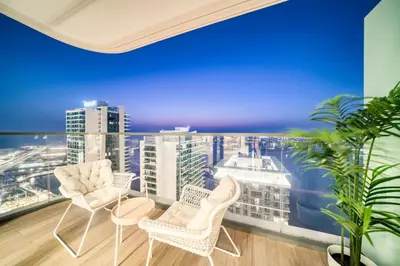 a balcony with chairs and a view of the city at Marina Vista 1BR Sea View Luxury Escape in Dubai