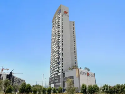 a tall white building with a sign on it at WelHome - Relaxing and Fancy Studio Apt with City View in Dubai