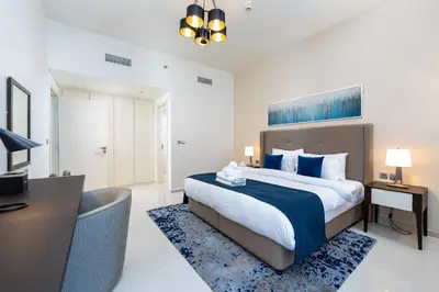 a bedroom with a large bed and a desk and a bed at Marco Polo - Modern 1BR in Business Bay near Burj Khalifa in Dubai