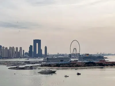 a city skyline with a ferris wheel in the water at The Smart Concierge - Seven Palm in Dubai