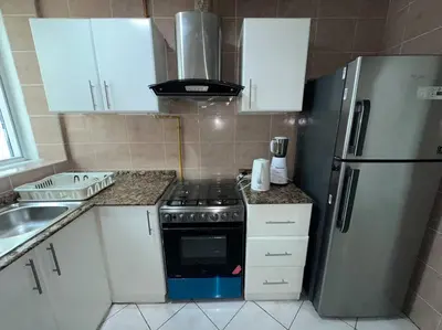 a kitchen with a stove and a refrigerator at Cozy 2 Bedroom Retreat in Dubai