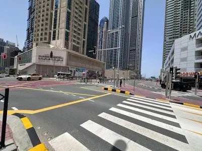 an empty street in a city with tall buildings at Cozy 2 Bedroom Retreat in Dubai