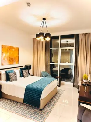 a bedroom with a large bed and a living room at Ghalia Studio Apartment in Dubai
