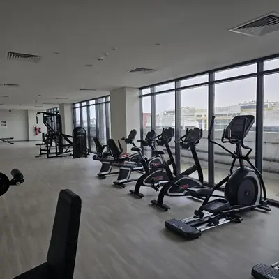 a gym with a lot of treadmills and exercise bikes at VESTA - Dubai Residence in Dubai
