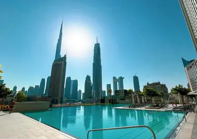 a large swimming pool in front of a city skyline at Luxury 2 BR Apartment, 5 Mins to Dubai Mall with Amazing view in DownTown Views 2 in Dubai