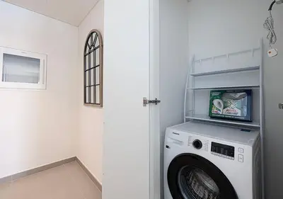 a washer and dryer in a white laundry room at Luxury 2 BR Apartment, 5 Mins to Dubai Mall with Amazing view in DownTown Views 2 in Dubai