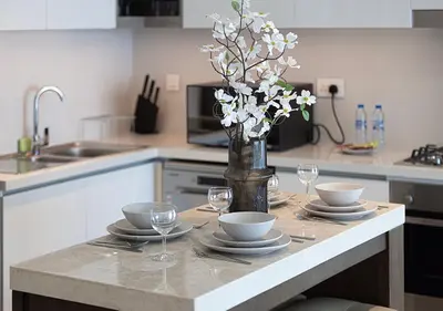 a kitchen with a table with glasses and a vase with flowers at Luxury 2 BR Apartment, 5 Mins to Dubai Mall with Amazing view in DownTown Views 2 in Dubai