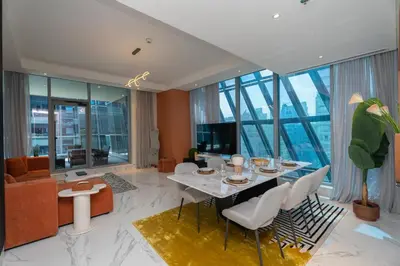 a living room with a table and chairs and a couch at Escape24 2BR Huge Terrace with Canal View in Dubai