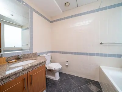 a bathroom with a toilet and a sink and a tub at Spacious 2 Bedroom Apartment in Tecom in Dubai