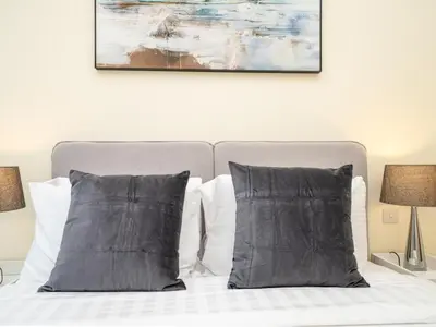 a bed with two pillows and a painting above it at Spacious 2 Bedroom Apartment in Tecom in Dubai