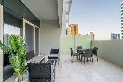a balcony with chairs and tables on a building at GuestReady - Modern living at Reva Residence in Dubai