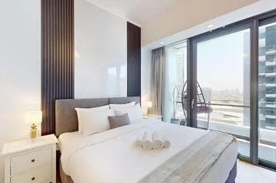 a bedroom with a white bed with a large window at Silverene Tower B - Exciting Two Bedroom in Dubai