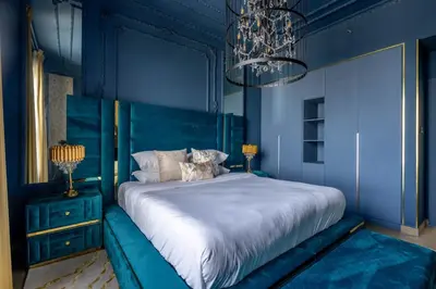 a blue bedroom with a bed and a chandelier at GuestReady - Luxurious living with sea view in Dubai