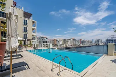 a swimming pool with a view of the water and buildings at GuestReady - Luxurious living with sea view in Dubai