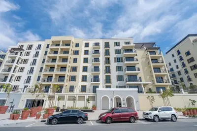 a large white building with cars parked in a parking lot at GuestReady - Luxurious living with sea view in Dubai